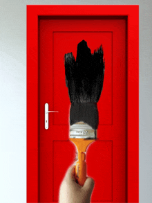 a person is holding a paint brush in front of a red door that says 20mm on it