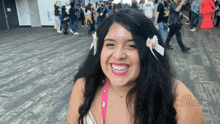 a woman wearing a flower in her hair is smiling in front of a sign that says ' standing times '