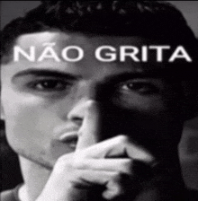 a black and white photo of a man covering his mouth with his finger and the words " nao grita " written above him