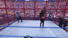 a wrestling match is taking place in a ring with a referee watching .