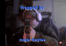 a man wearing headphones is holding a gun with the words fragged by major baylee written below him