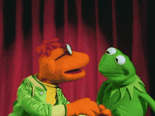 kermit the frog is shaking hands with mr. frog