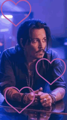 a man is sitting at a table with hearts around him