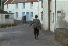 a man in a suit is walking down a street in front of a sign that says ' no parking ' on it