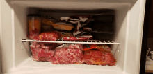 a freezer filled with a variety of foods including a bag of beef