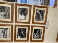 a collection of framed black and white photographs on a white board