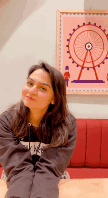 a woman sitting in front of a ferris wheel with a picture of a soldier in the background