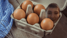 a carton of brown eggs with a man 's face in the center