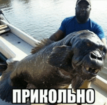 a man in a boat holding a large fish with a caption that says prikolno