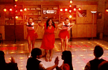 three cheerleaders are dancing on a dance floor