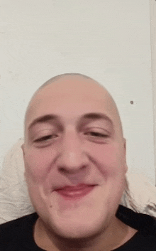 a close up of a man 's face with a shaved head .