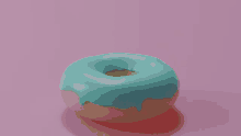 a donut with blue frosting is on a pink background