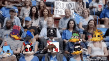 a crowd of people sitting in a stadium with a sign that says run the