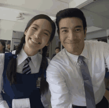 a man and a girl are posing for a picture and the girl is wearing a school uniform with a crest on it