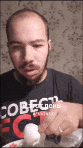 a man with a beard wearing a shirt that says " cobect " on it