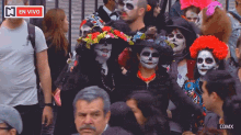 a group of people dressed in day of the dead costumes are standing in front of a sign that says en vivo