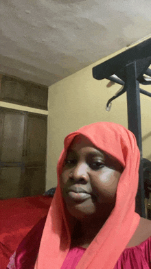 a woman with a red scarf around her head looks at the camera