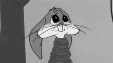 bugs bunny is crying in a black and white cartoon while standing next to a wall .