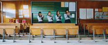 a group of girls playing instruments in front of a blackboard with a sign that says ' ao ' on it