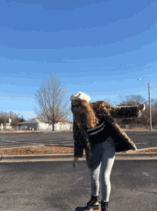 a woman wearing a fur coat and a beret is standing on the side of the road with her arms outstretched