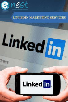 a person holding a cell phone with the linkedin logo on the screen