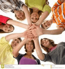 a group of young people are stacking their hands in a circle .