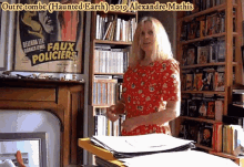 a woman in a red dress is standing in front of a bookshelf with a poster for faux policiers on it