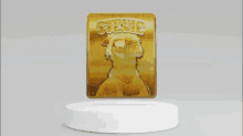 a gold steve album cover is on display on a white podium