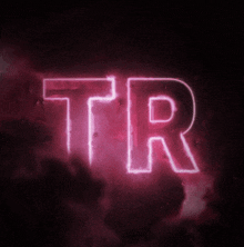 a neon sign that says tr in a dark room