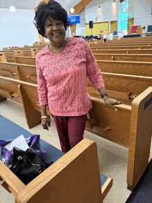 a woman in a pink top stands in a church