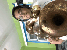 a man wearing glasses and headphones holds a trumpet