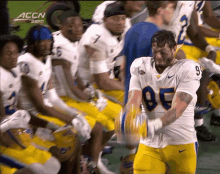 a football player with the number 86 on his jersey is dancing with his teammates