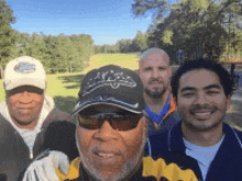 a group of men are posing for a picture with one wearing a hat that says tigers