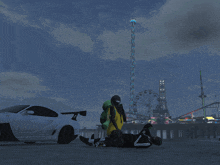 a man laying on the ground in front of a ferris wheel and a car