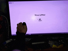 a person 's foot is visible in front of a computer monitor that says rogue loneage