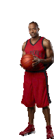 a man wearing a red devils jersey holds a basketball