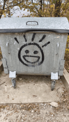 a smiley face is painted on a trash can