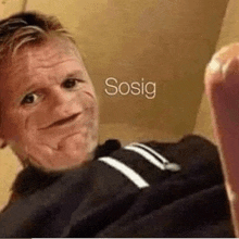 a man is making a funny face with his mouth open and the word sosig written above him .