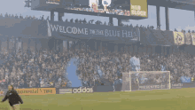 a soccer field with a banner that says welcome to the blue hell on it