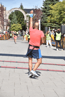 a man in a red shirt stands in front of a sign that says " philadelphia marathon "