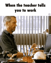 a man is sitting at a desk in front of a computer with the words " when the teacher tells you to work "