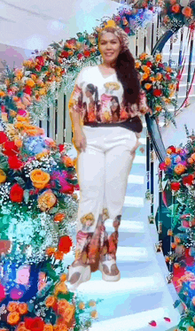 a woman is standing on a set of stairs surrounded by colorful flowers