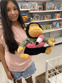 a girl holding a stuffed monkey with a flamingo float on its back