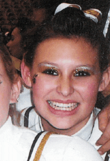 a young girl with a bee on her face smiles for the camera