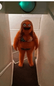 a stuffed animal dressed as a woman in a bikini is standing on a set of stairs .