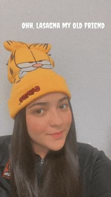 a girl wearing a yellow garfield hat with the words ohh lasagna my old friend above her