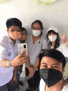 a group of people wearing face masks are posing for a photo