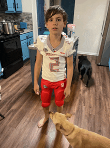 a young boy wearing a football jersey with the number 2