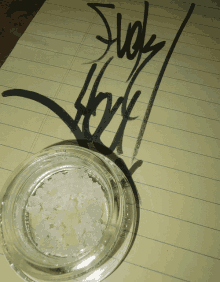 a jar of weed sits on a piece of paper next to a drawing that says suck hot