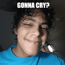 a young man in a blue shirt is smiling with a caption that says " gonna cry "